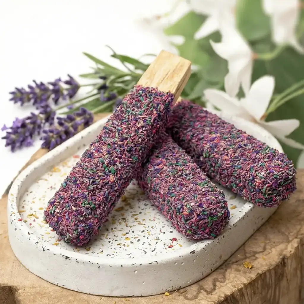 Varillas de palo santo cubiertas con lavanda seca sobre plato cerámico para limpieza energética y aromaterapia